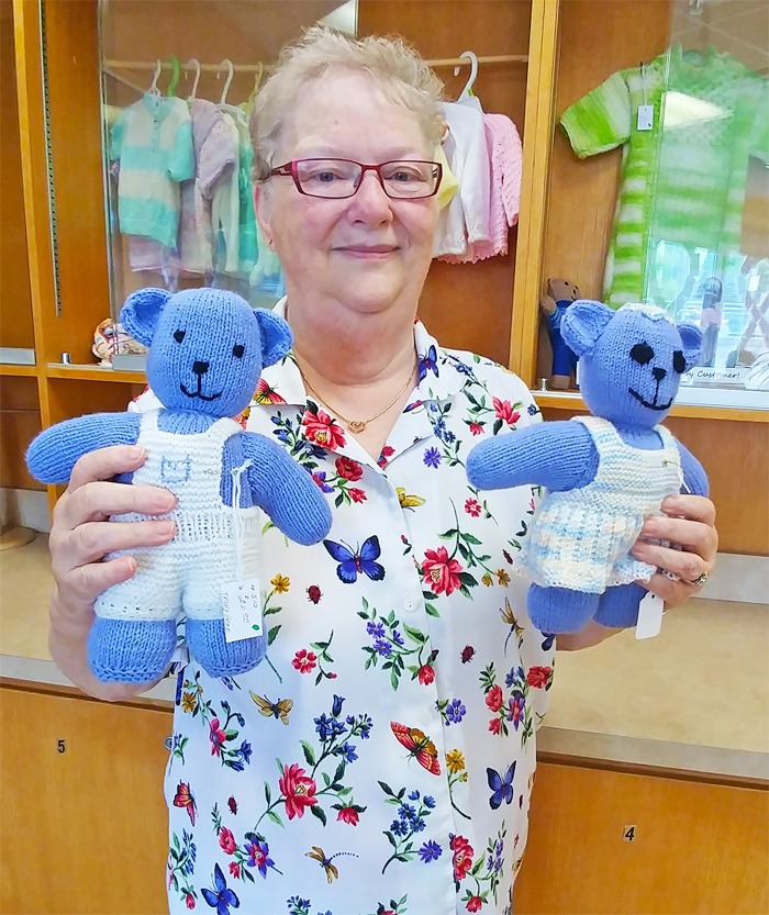 older lady volunteer holding two baby toy bears
